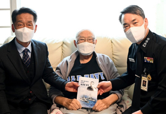 최영섭 예비역 대령(가운데)이 지난 14일 자택에서 해군이 발간한 '지략·용기·덕망을 겸비한 최영섭 대령' 평전을 전달받고 기념촬영을 하고 있다. [출처=해군]